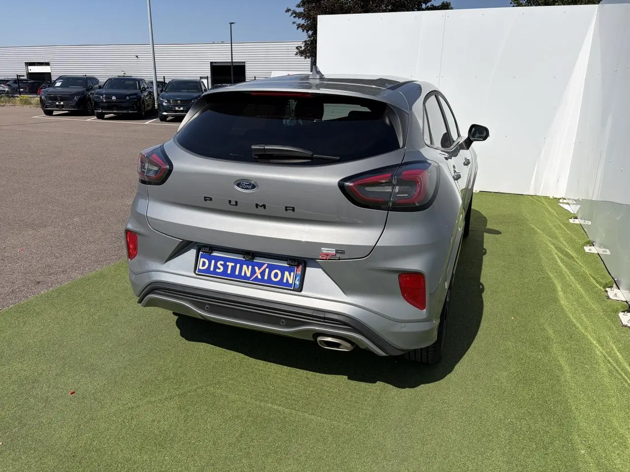 Vue 3/4 arrière droite d'une Ford Puma gris métal finition ST-Line avec feux LED et sortie d'échappement chromée visible.