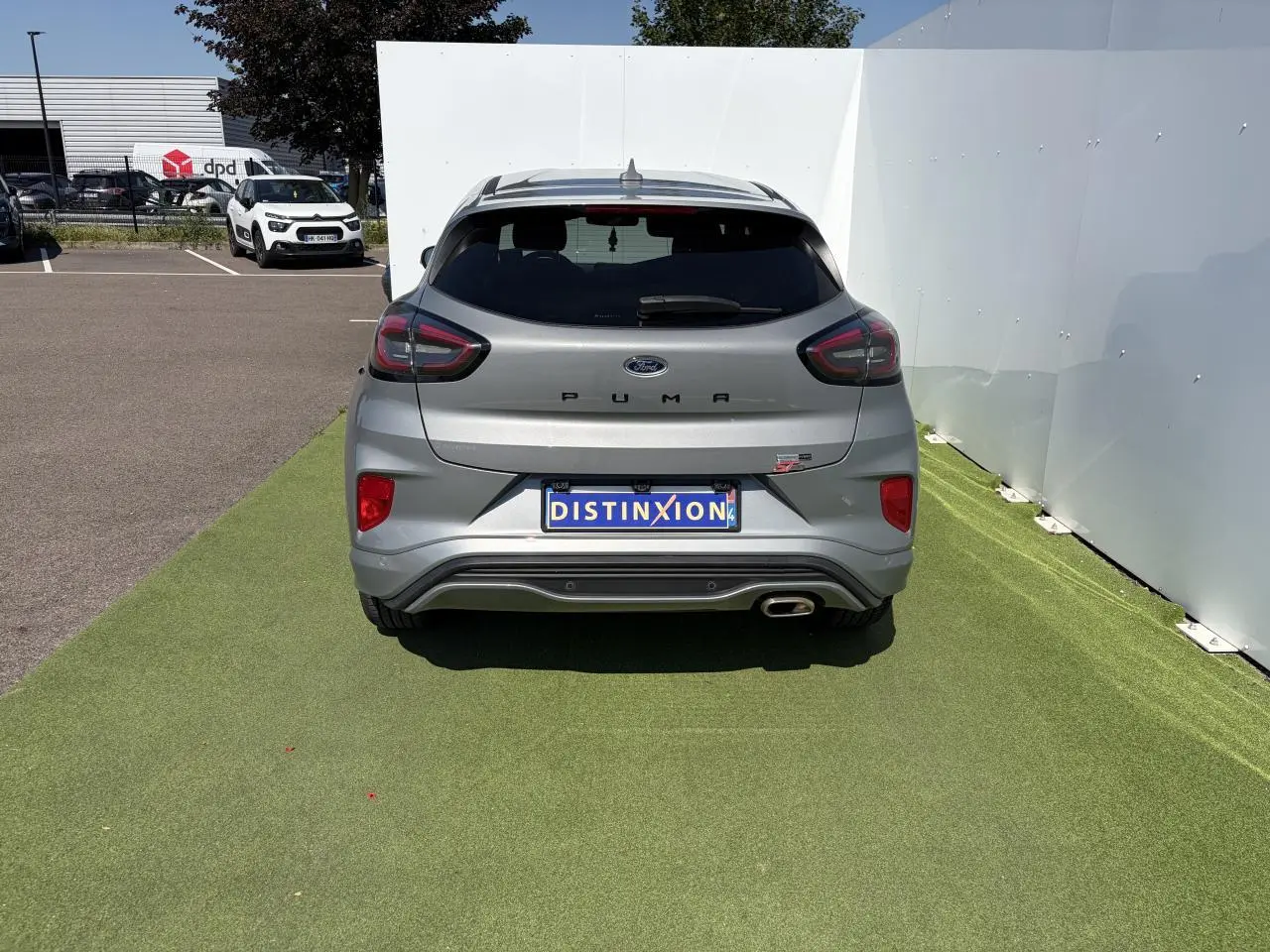 Vue arrière d'un Ford Puma gris métal avec logo ST-Line et sortie d'échappement chromée visible.