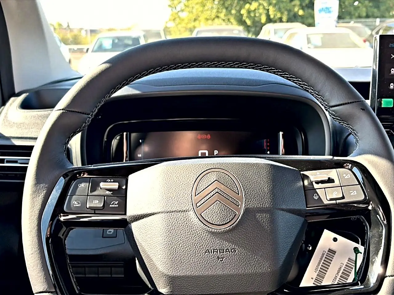 Volant cuir multifonction de Citroën Berlingo 2026, vue frontale rapprochée sur le tableau de bord noir.