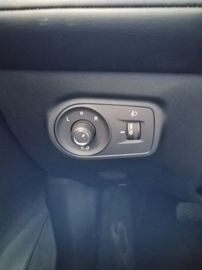 Gros plan sur les commandes de réglage des rétroviseurs et de l’éclairage, intérieur noir du MG ZS 1.5 l Hybrid+ 2026.