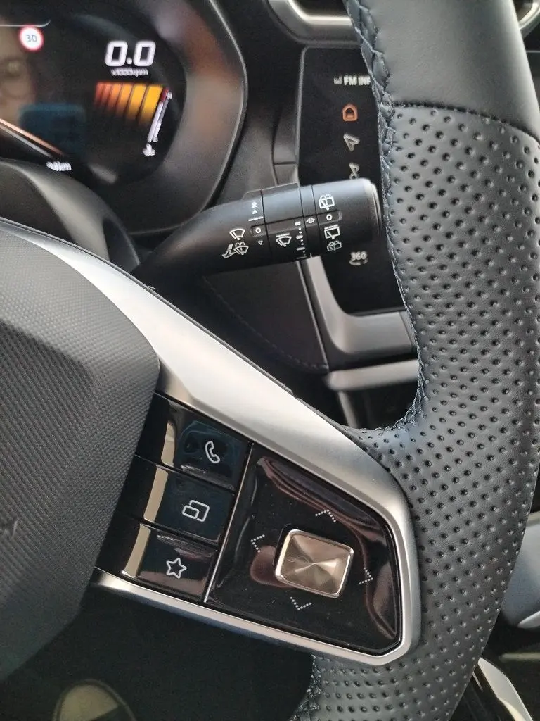 Gros plan sur la commande de volant en cuir perforé noir et la manette d’essuie-glace du MG MOTOR ZS 1.5 l Hybrid + 197 Luxury Cosmic Silver.