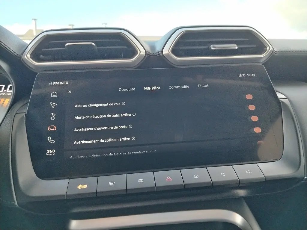 Vue rapprochée de l'écran tactile central du MG Motor ZS 1.5 l Hybrid + 197 Luxury en Cosmic Silver, affichant les options d'aide à la conduite.