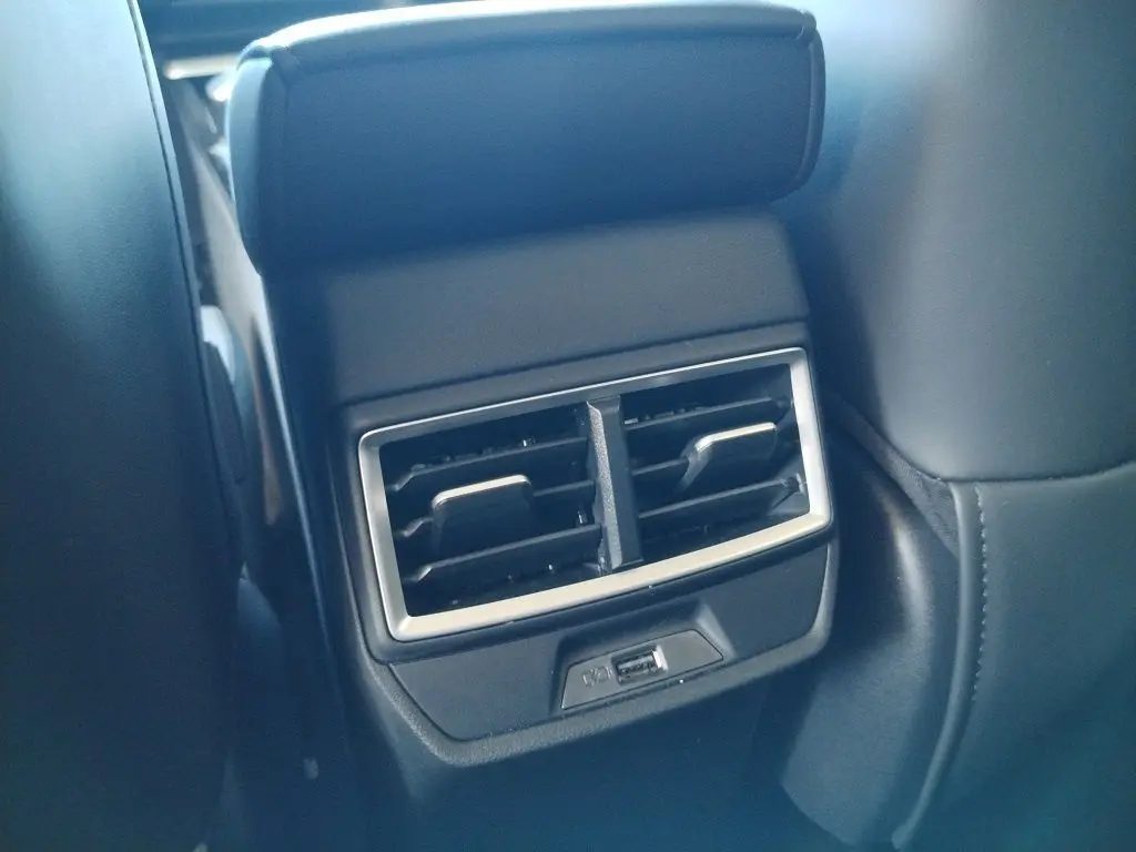 Gros plan sur la sortie d'air arrière avec port USB du MG MOTOR ZS 1.5 l Hybrid + 197 LUXURY, intérieur noir.