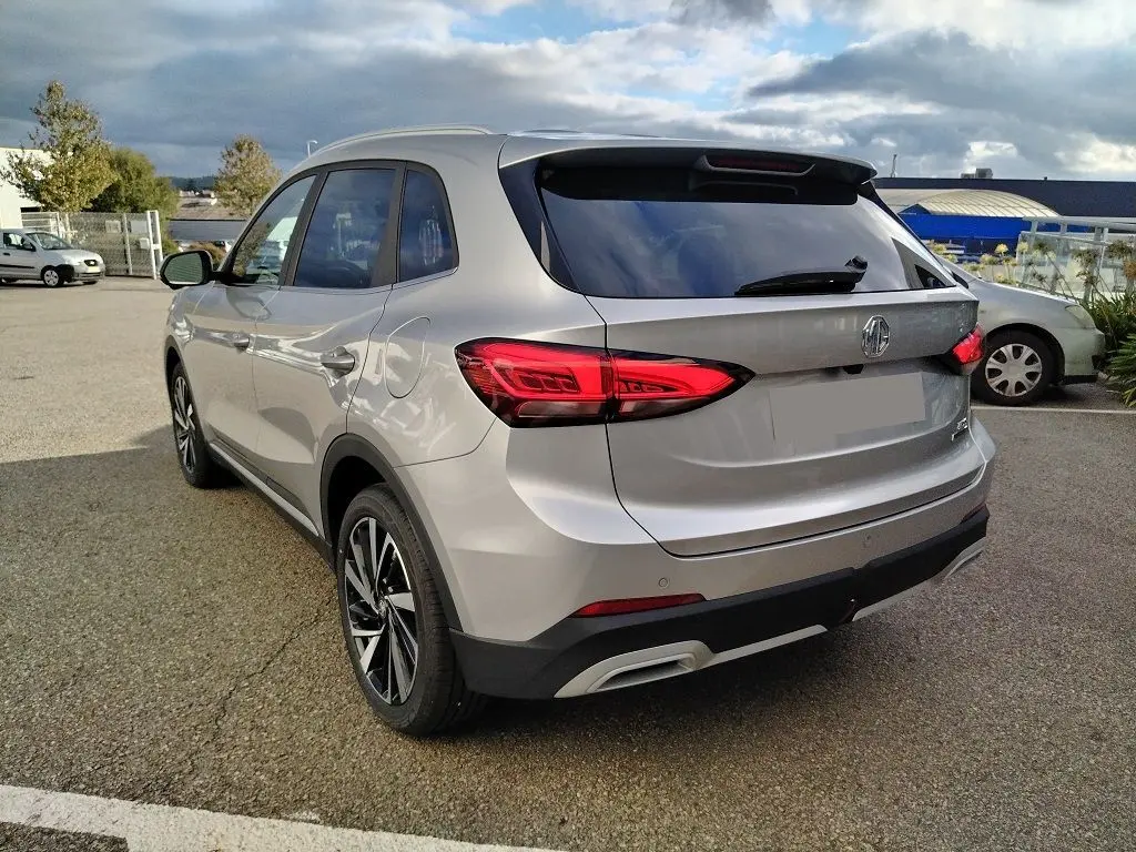 Vue 3/4 arrière droite du MG ZS 1.5 l Hybrid Cosmic Silver, avec feux arrière LED et jantes alliage noires.