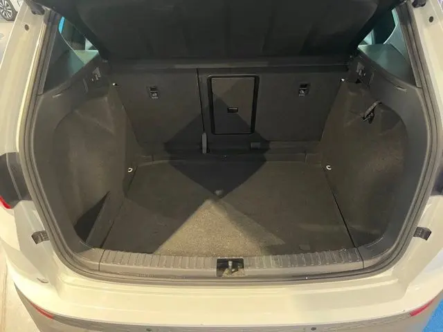 Coffre ouvert vu de l'arrière d'un SEAT Ateca blanc Nevada, montrant un espace de chargement propre et spacieux.