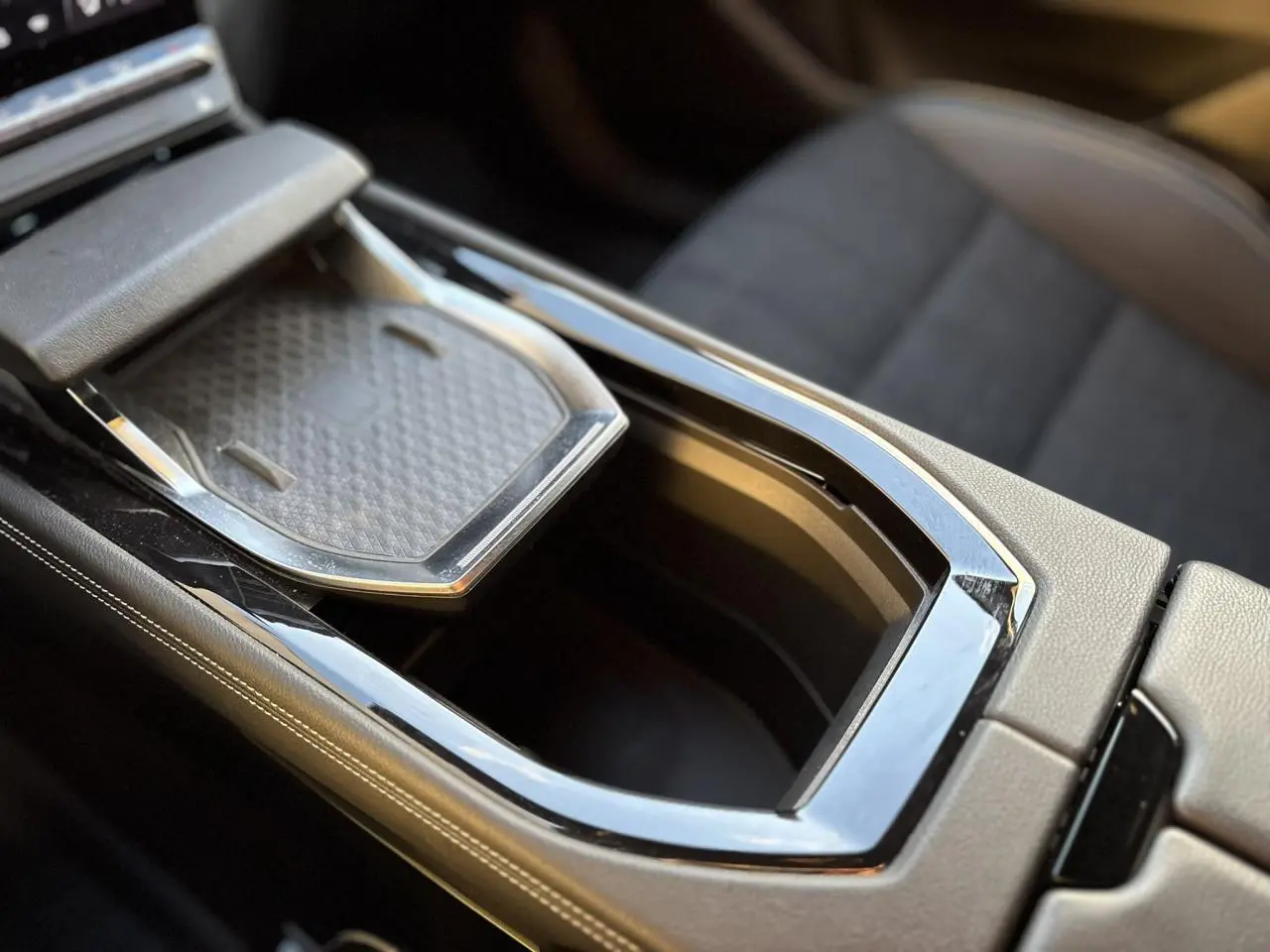 Gros plan sur la console centrale du Renault Austral 2023 avec compartiment ouvert et finition cuir beige.