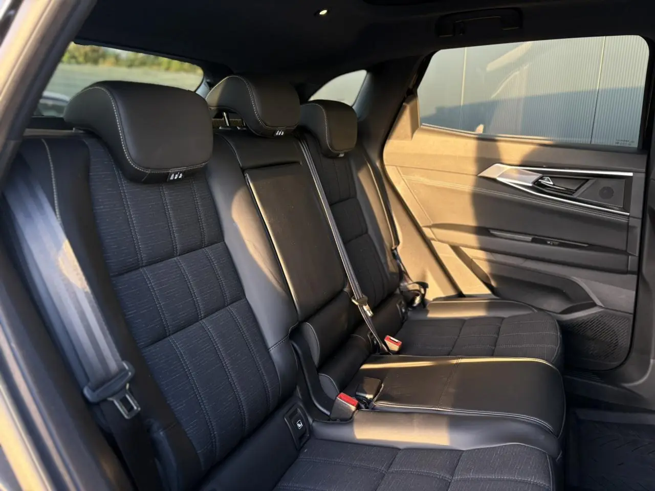 Vue latérale droite des sièges arrière noirs en tissu et similicuir avec surpiqûres or du Renault Austral 2023.