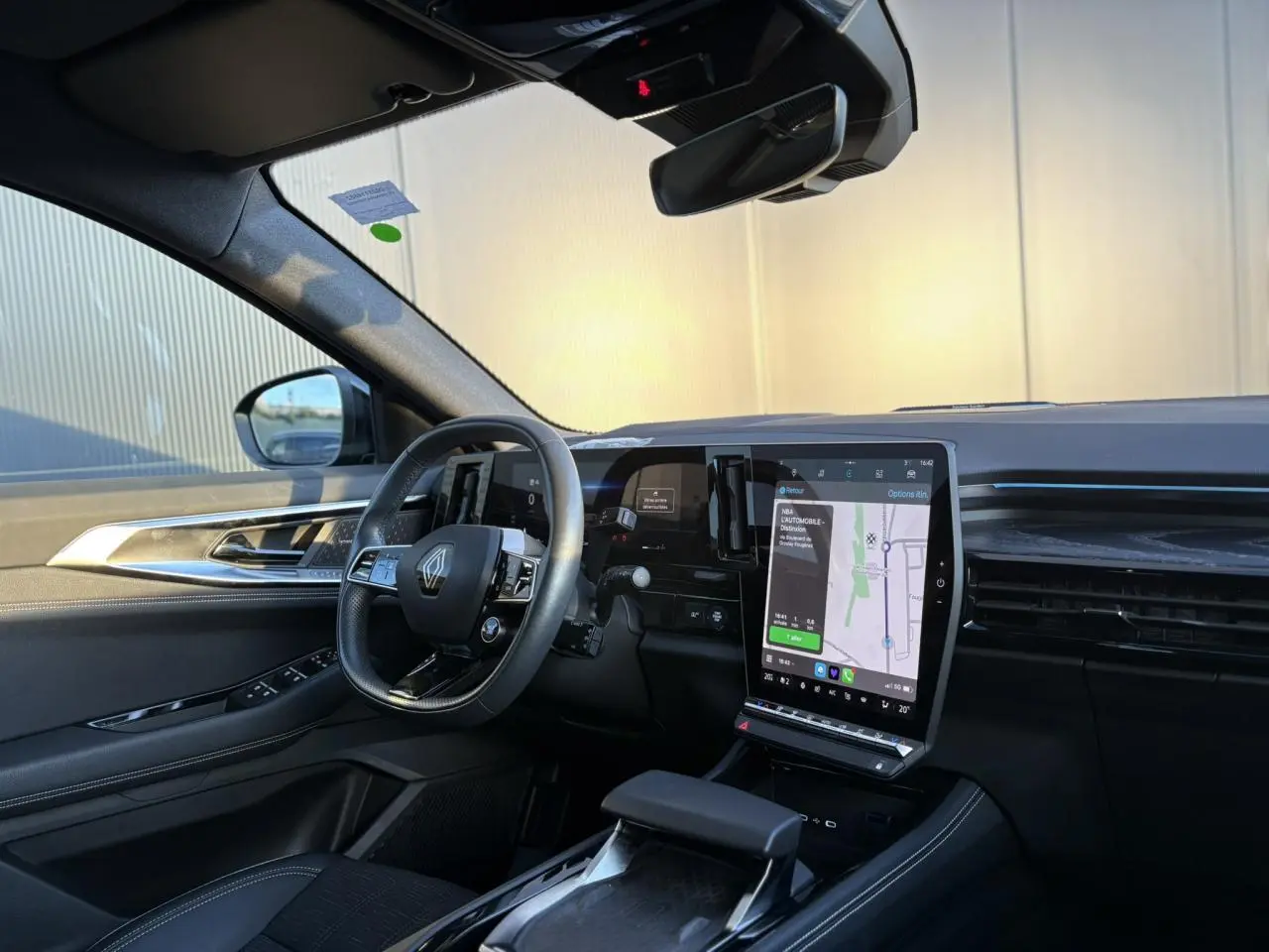 Intérieur du Renault Austral 2023 côté conducteur, avec volant cuir, grand écran tactile vertical et sellerie noire.