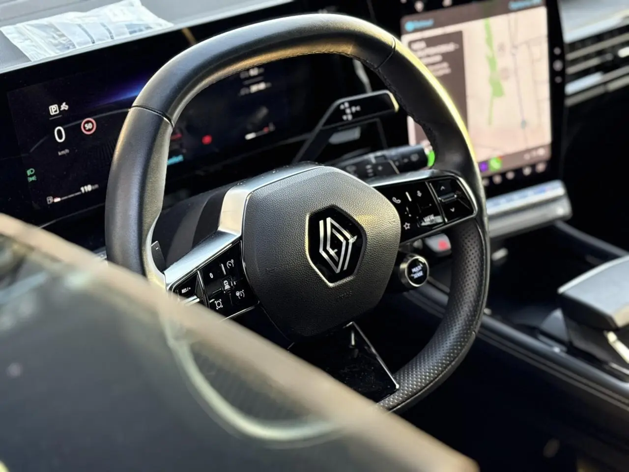Vue rapprochée du volant cuir et du tableau de bord numérique du Renault Austral 2023 noir étoile.