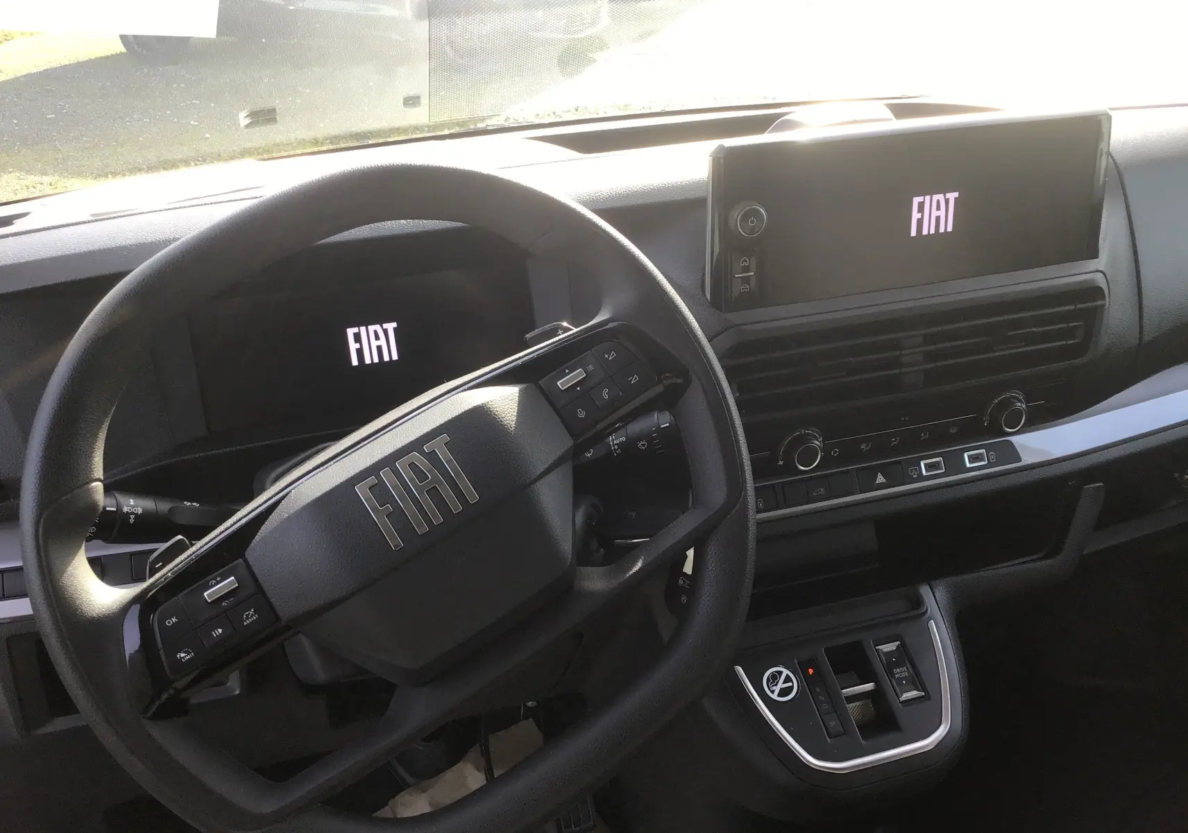 Vue intérieure du tableau de bord du Fiat Scudo Fourgon 2024, avec volant multifonction et écran tactile affichant le logo FIAT.