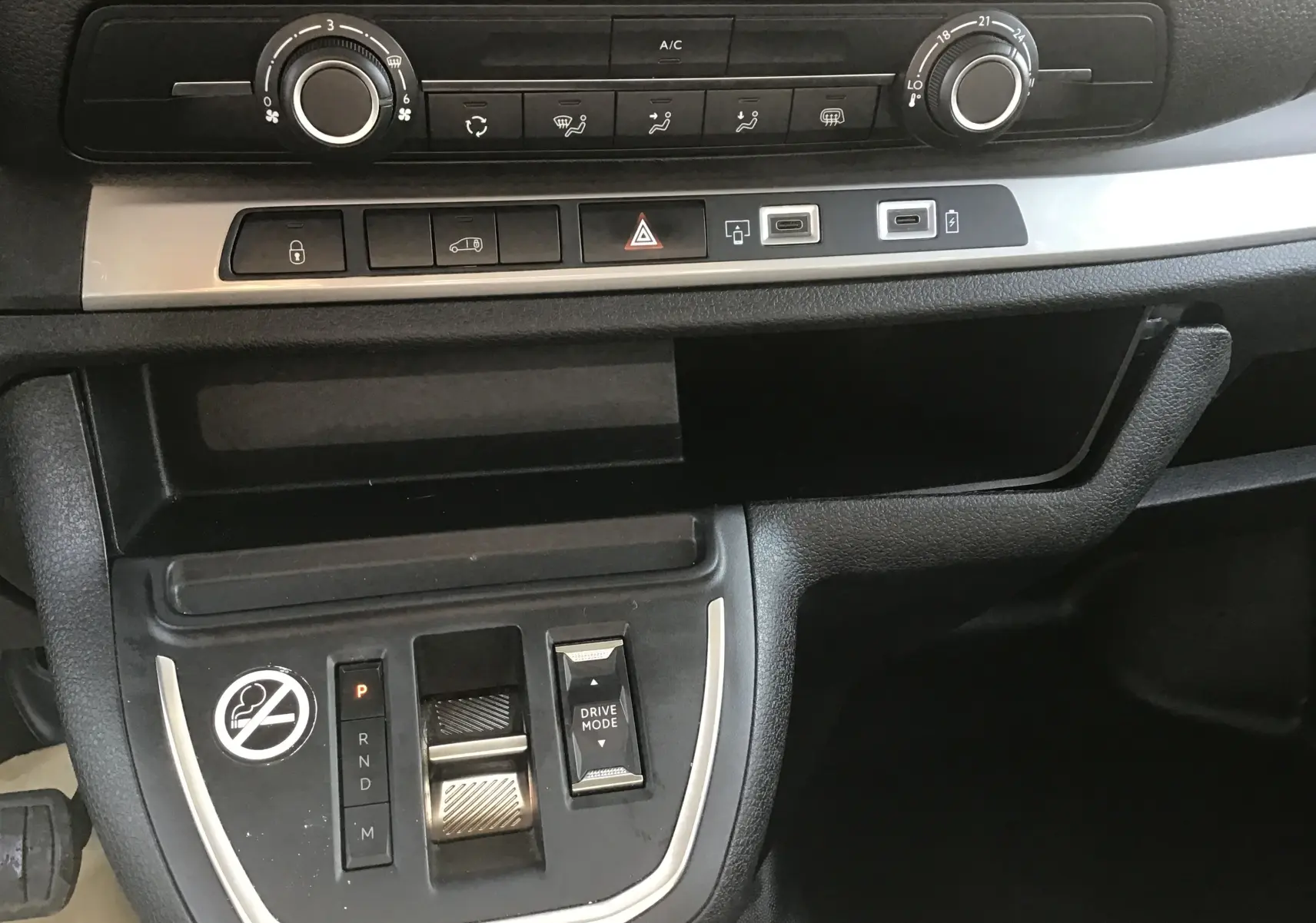 Vue rapprochée du tableau de bord et console centrale noire du Fiat Scudo Fourgon blanc, avec commandes climatisation et boîte auto.