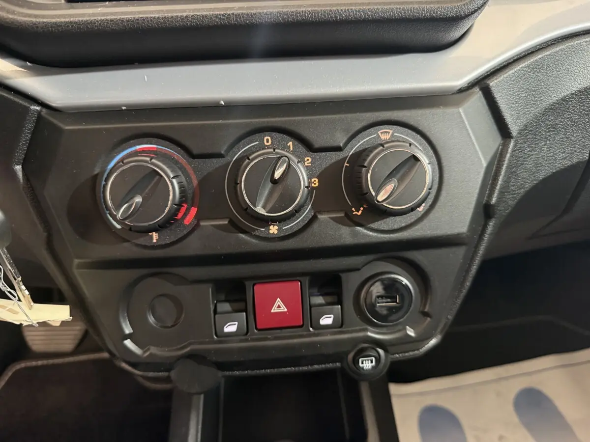 Gros plan sur les commandes de climatisation et les boutons de l’AIXAM AMBITION 0.5 CROSSOVER PREMIUM gris foncé, tableau de bord intérieur.