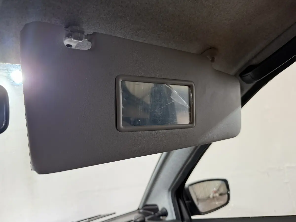 Détail du pare-soleil côté conducteur avec miroir intégré dans l’habitacle d’une Aixam Ambition gris foncé.