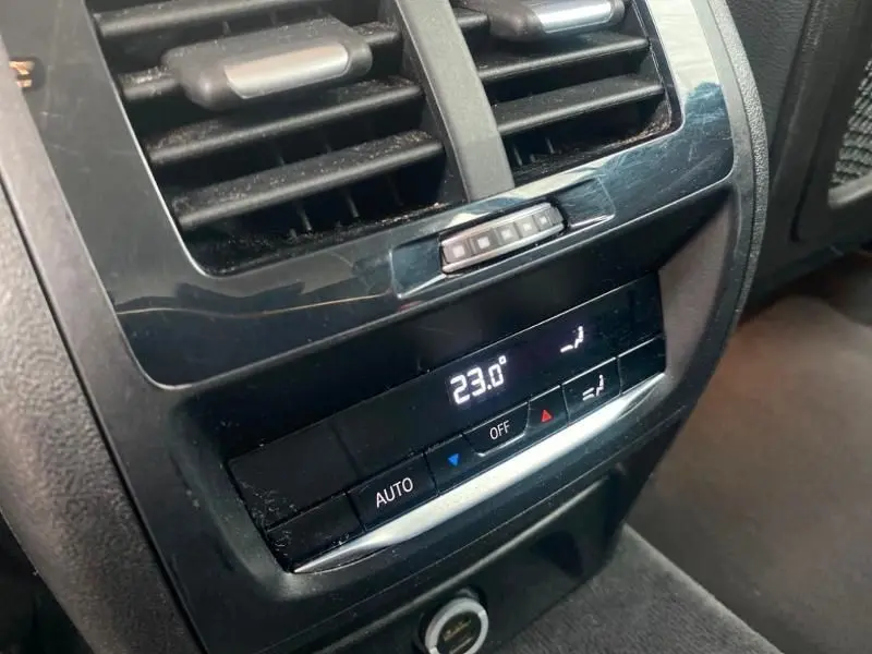 Détail de la commande de climatisation arrière noire du BMW X3 X-DRIVE 20 DA bleu métal, affichant 23 degrés.