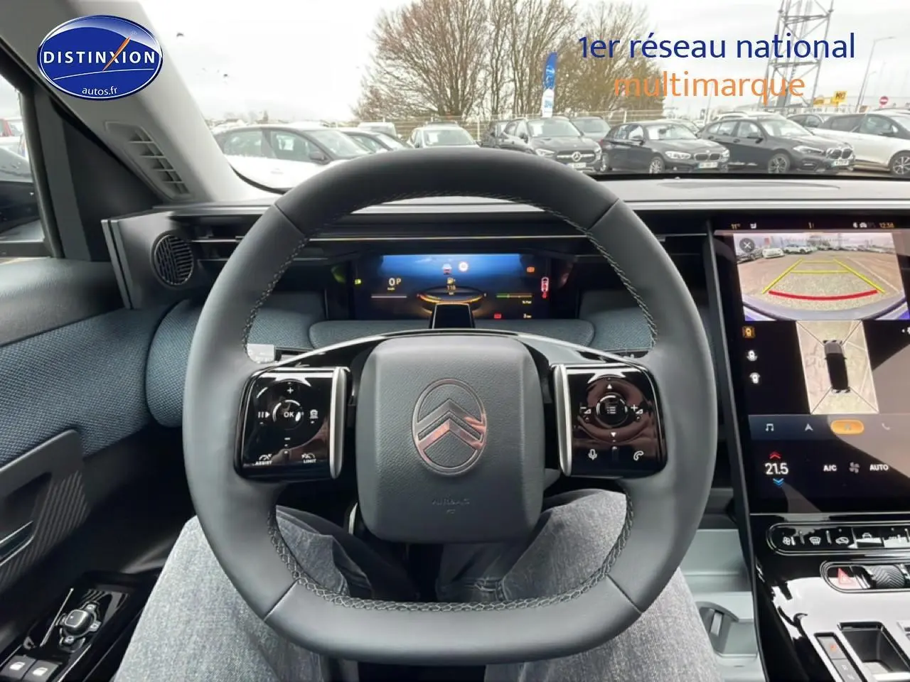 Vue intérieure centrée sur le volant du Citroën C5 Aircross 2026, avec écran tactile et affichage tête haute visible.