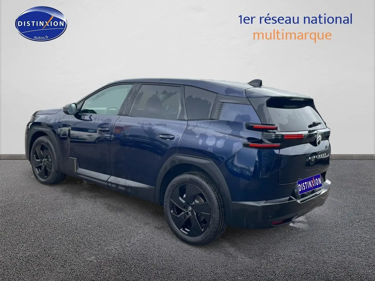 Vue 3/4 arrière droite d'un Citroën C5 Aircross bleu 2026 avec jantes noires et feux arrière LED horizontaux.