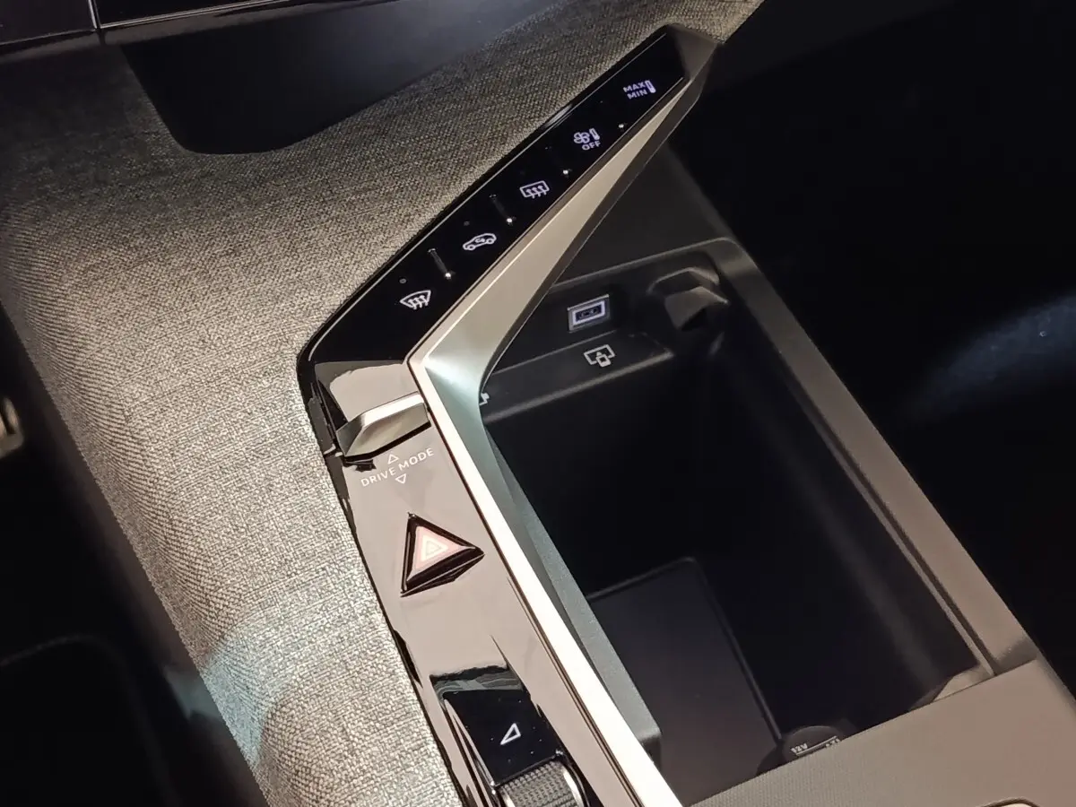 Gros plan sur la console centrale grise du Peugeot 5008 2026 avec commandes tactiles et prise USB visible.