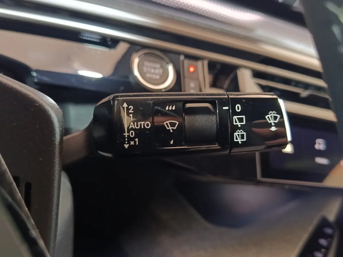 Gros plan sur la commande des essuie-glaces du Peugeot 5008 gris clair, avec bouton démarrage en arrière-plan.