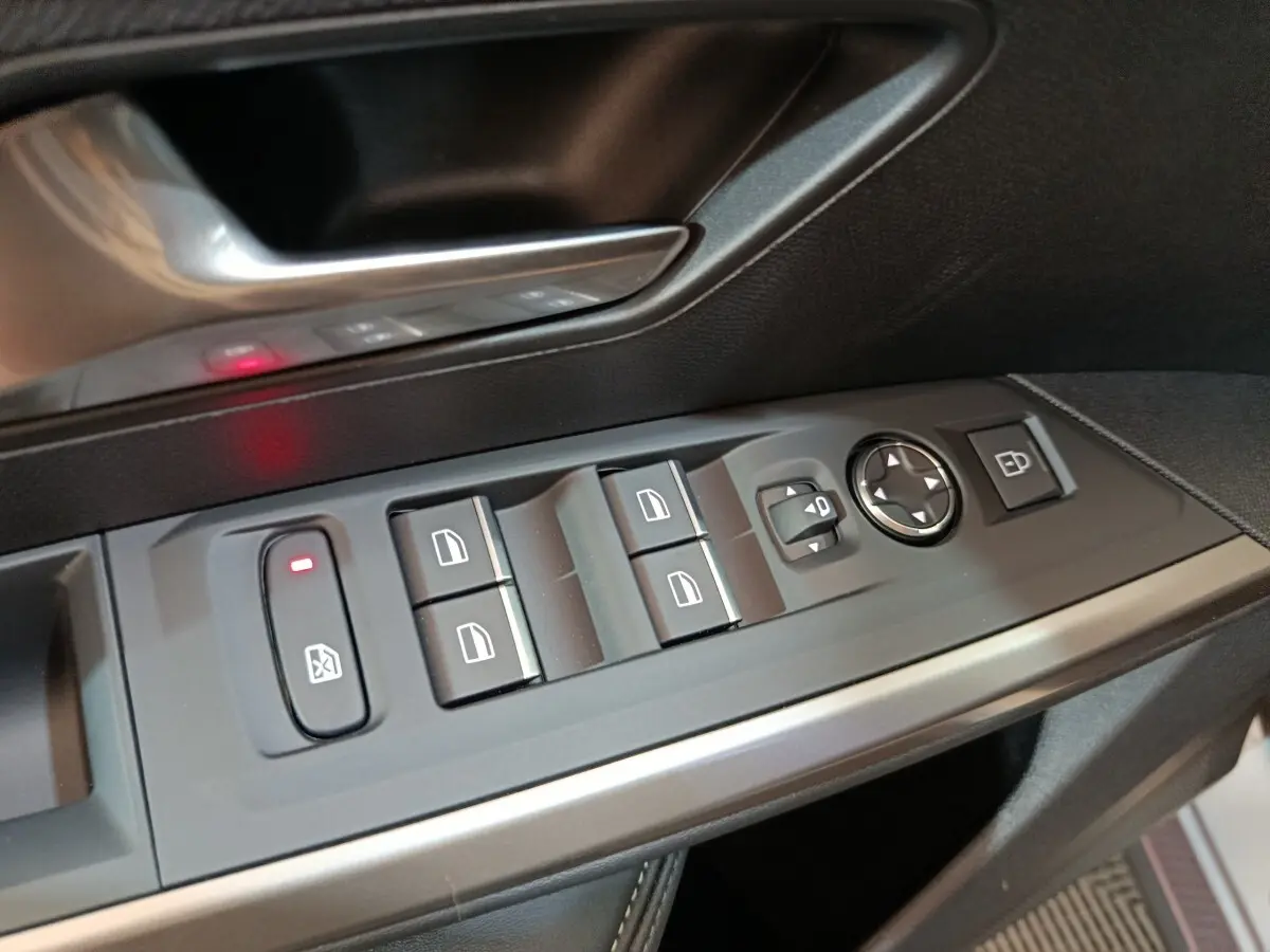 Détail des commandes de lève-vitres et rétroviseurs côté conducteur du Peugeot 5008 gris clair, intérieur noir.