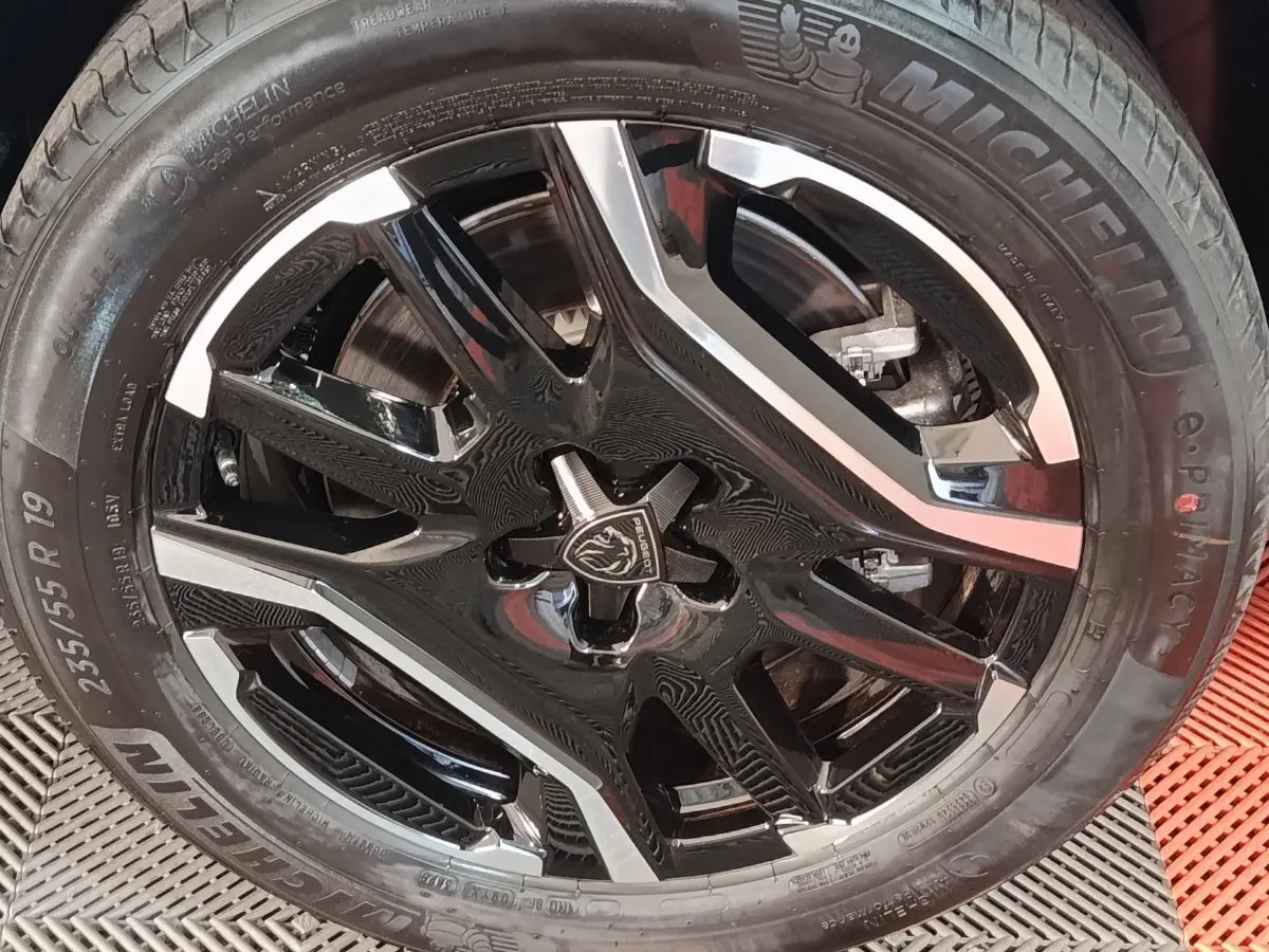 Gros plan sur la jante noire et argentée de 19 pouces du Peugeot 5008 gris clair, pneu Michelin visible.