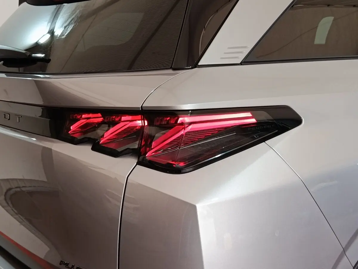 Feu arrière droit allumé sur Peugeot 5008 gris clair, vue rapprochée du côté arrière droit du véhicule.