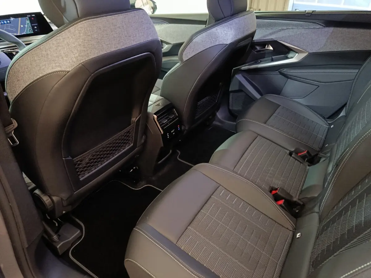 Vue intérieure arrière côté droit du Peugeot 5008 gris clair, montrant les sièges en tissu et cuir avec coutures contrastées.
