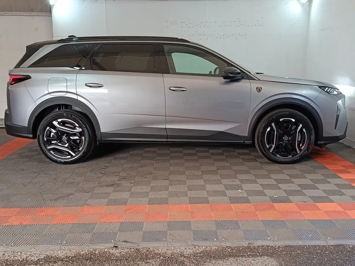 Peugeot 5008 gris clair vue de profil côté gauche, SUV hybride rechargeable avec jantes noires brillantes.