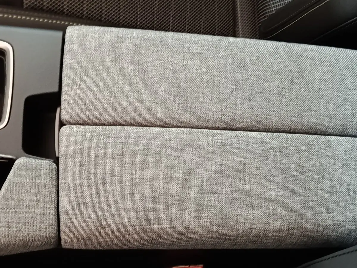 Détail de l'accoudoir central en tissu gris clair à l'intérieur du Peugeot 5008 1.6 PHEV 195 E-DCS7 GT 2026.