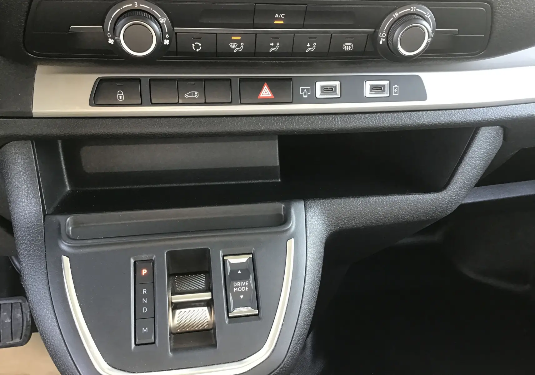 Vue rapprochée du tableau de bord et console centrale noire du Fiat Scudo Fourgon blanc, avec commandes climatisation et boîte auto.