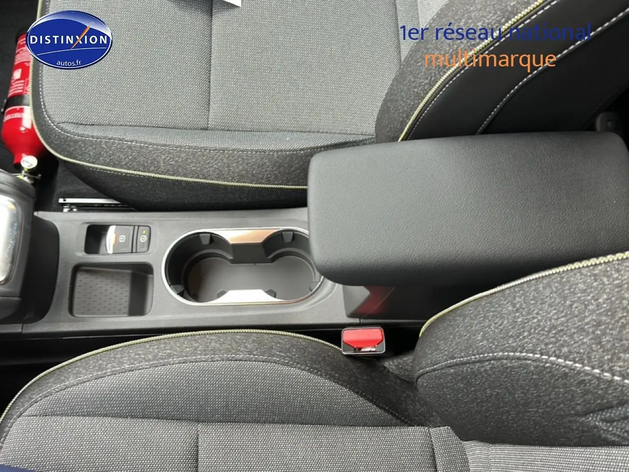 Vue plongeante sur l'accoudoir central et les sièges en tissu gris du Renault Captur 2025 finition Techno.