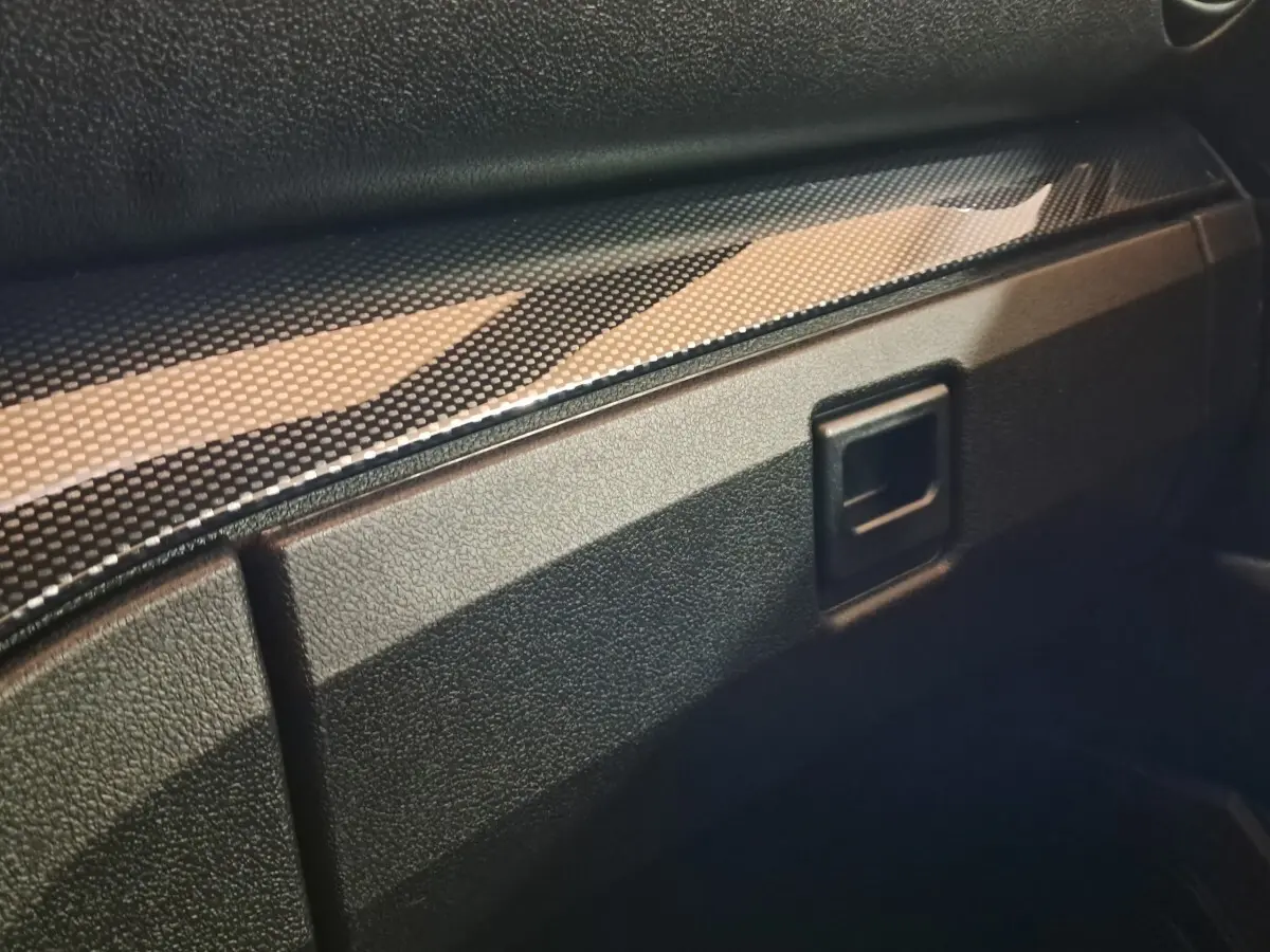 Détail intérieur du tableau de bord noir texturé avec insert imitation carbone de l'AIXAM AMBITION 0.5 CITY COUPE GTI blanc.