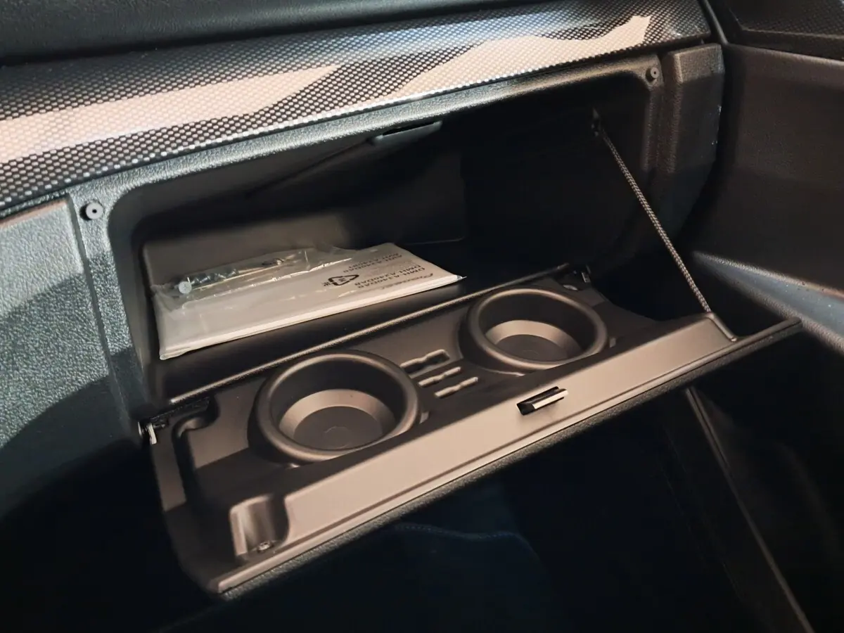 Intérieur de la boîte à gants ouverte de l'AIXAM AMBITION 0.5 CITY COUPE GTI 2026, avec porte-gobelets intégrés.
