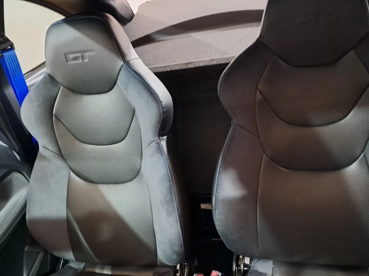 Gros plan sur les sièges avant noirs avec logo GT embossé, intérieur sportif de l'AIXAM AMBITION 0.5 CITY COUPE GTI.