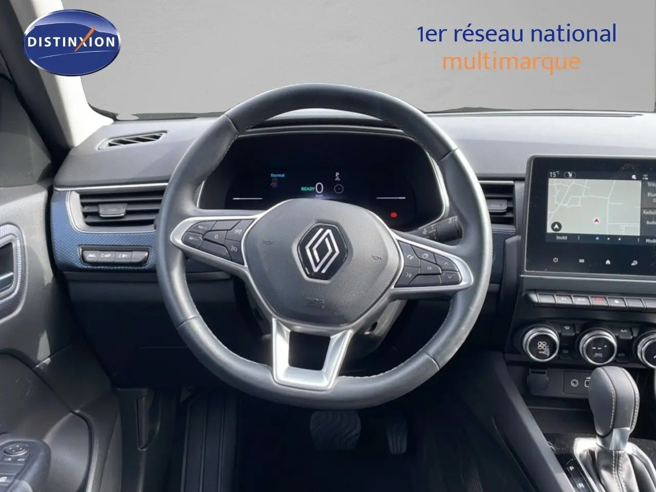 Vue intérieure centrée sur le volant noir du Renault Arkana 2024 avec tableau de bord digital et écran tactile.