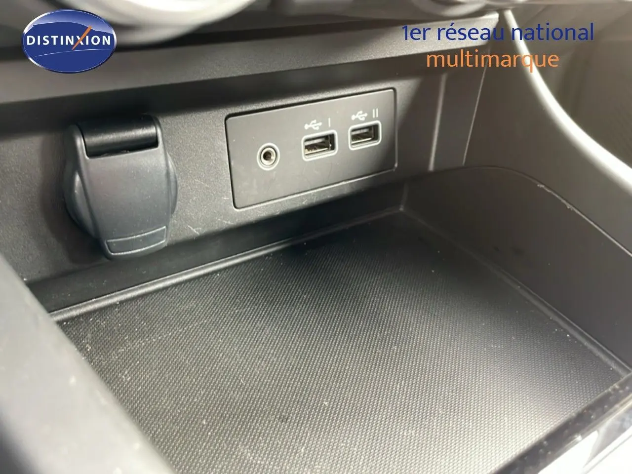 Vue rapprochée de la console centrale noire du Renault Arkana 2024 montrant les ports USB et prise auxiliaire.