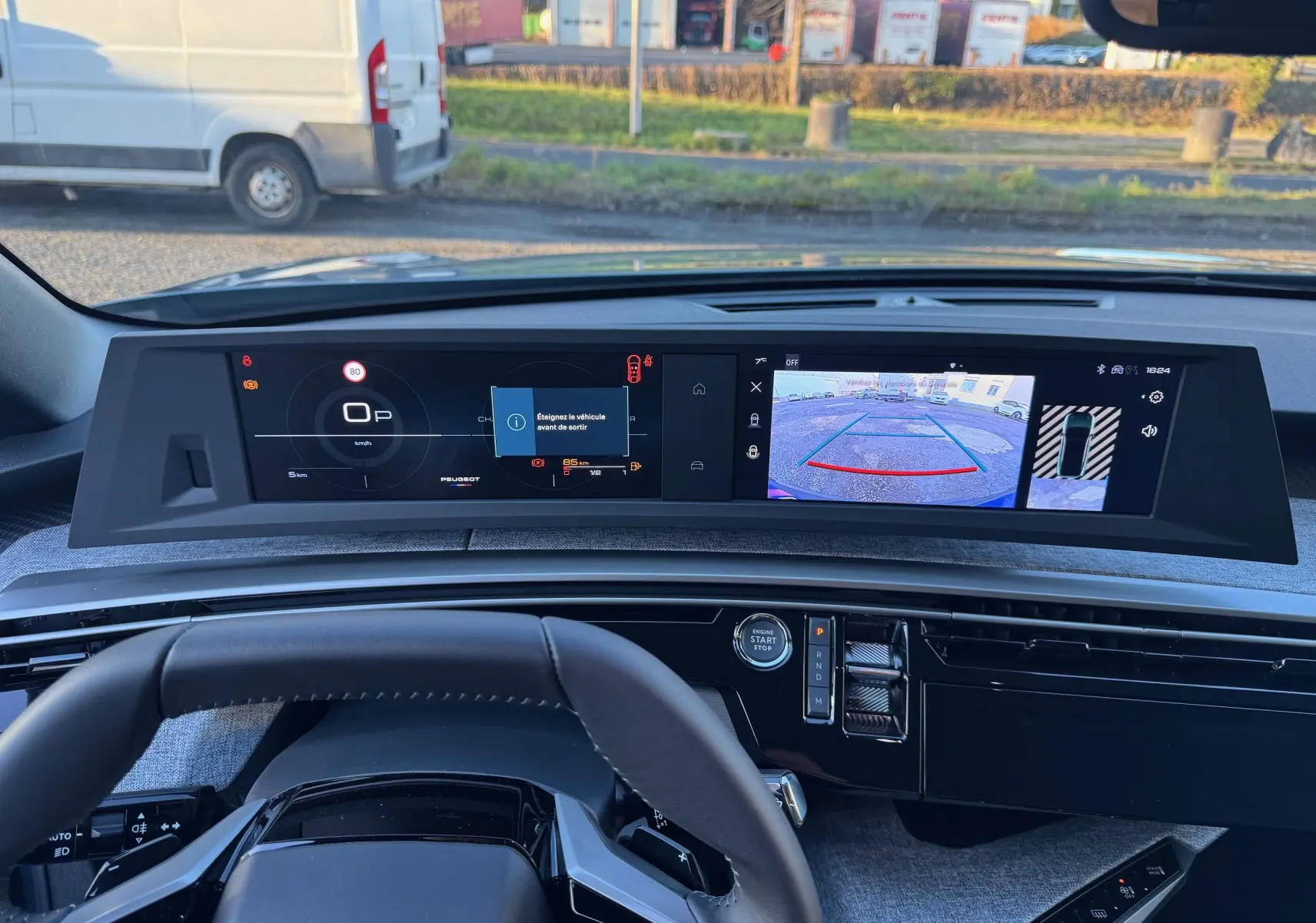 Vue intérieure du tableau de bord du Peugeot 3008 Hybrid 2025 avec écran numérique et caméra de recul affichée.