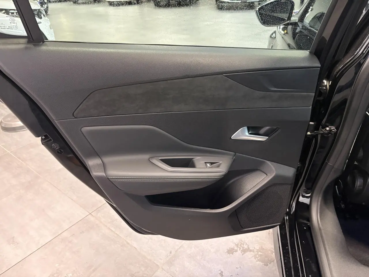 Vue intérieure de la porte arrière droite noire métallisée de la Peugeot 308 GT avec habillage noir et surpiqûres grises.