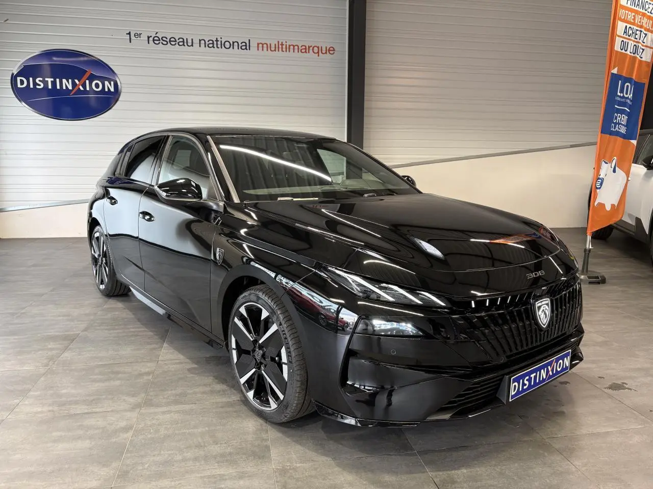 Peugeot 308 noir métallisé vue 3/4 avant droit en intérieur, avec calandre et jantes alliage distinctives.