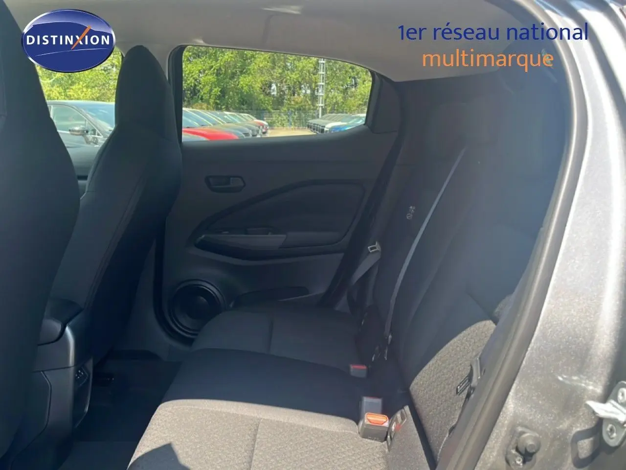Vue intérieure côté droit des sièges arrière du Nissan Juke gris squale metal, mettant en valeur l'habitacle spacieux et les finitions tissu noir.