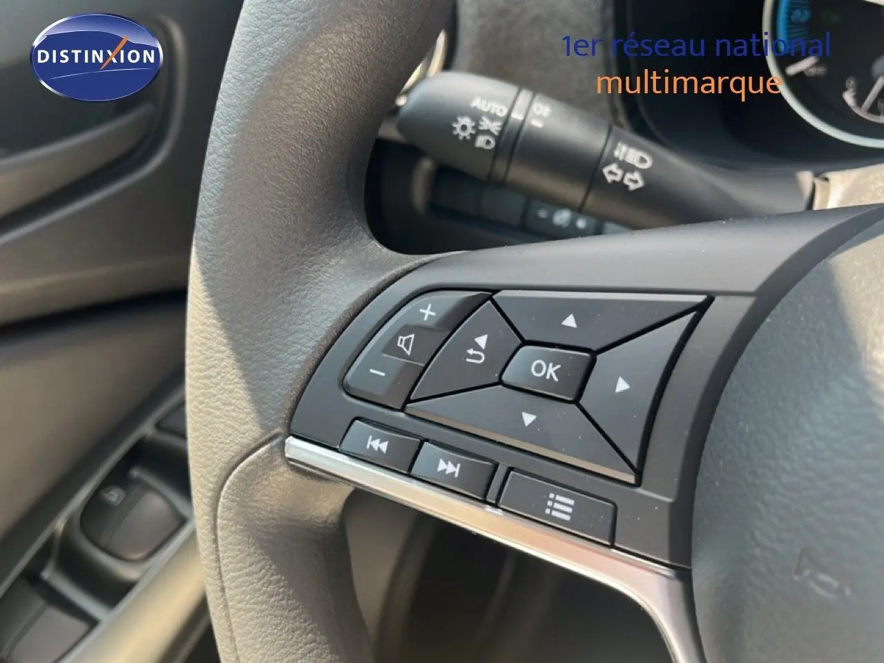 Gros plan sur les commandes au volant du Nissan Juke gris squale métal, mettant en valeur les boutons multifonctions.
