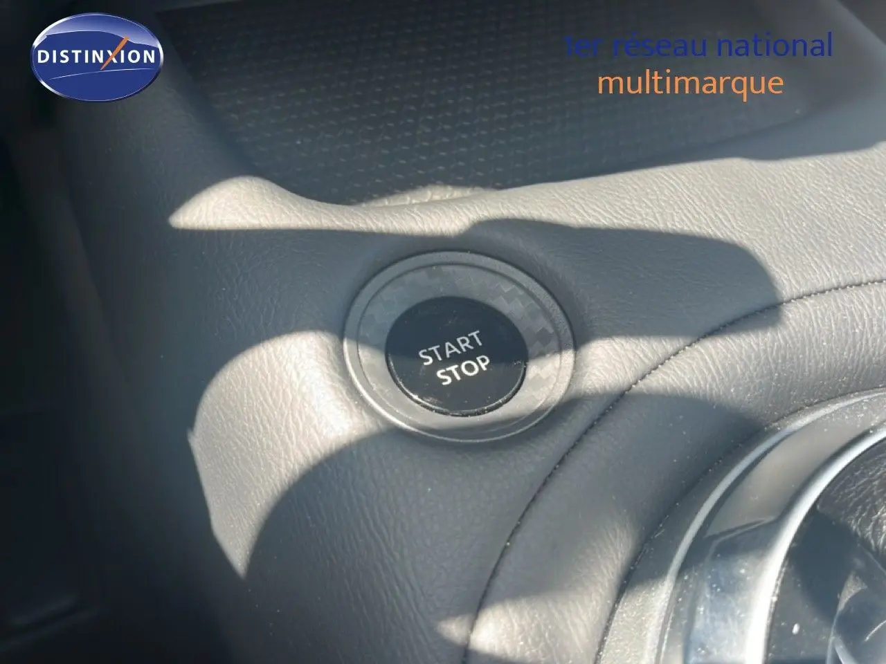 Bouton start/stop en gros plan sur la console intérieure d'une Nissan Juke gris squale metal 2025.