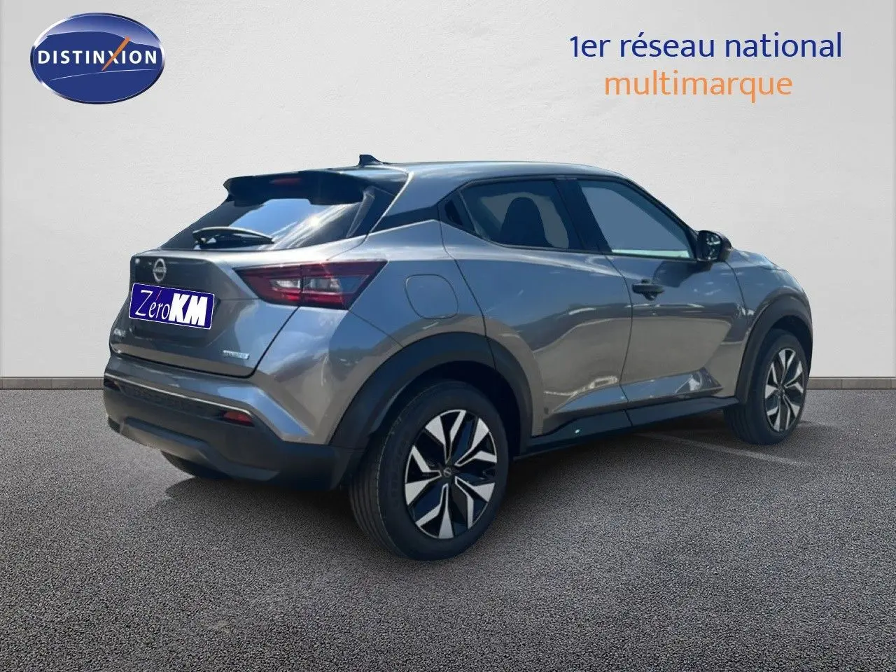 Nissan Juke Hybrid gris squale métal en 3/4 arrière droit, avec jantes alliage et feux arrière LED distinctifs.
