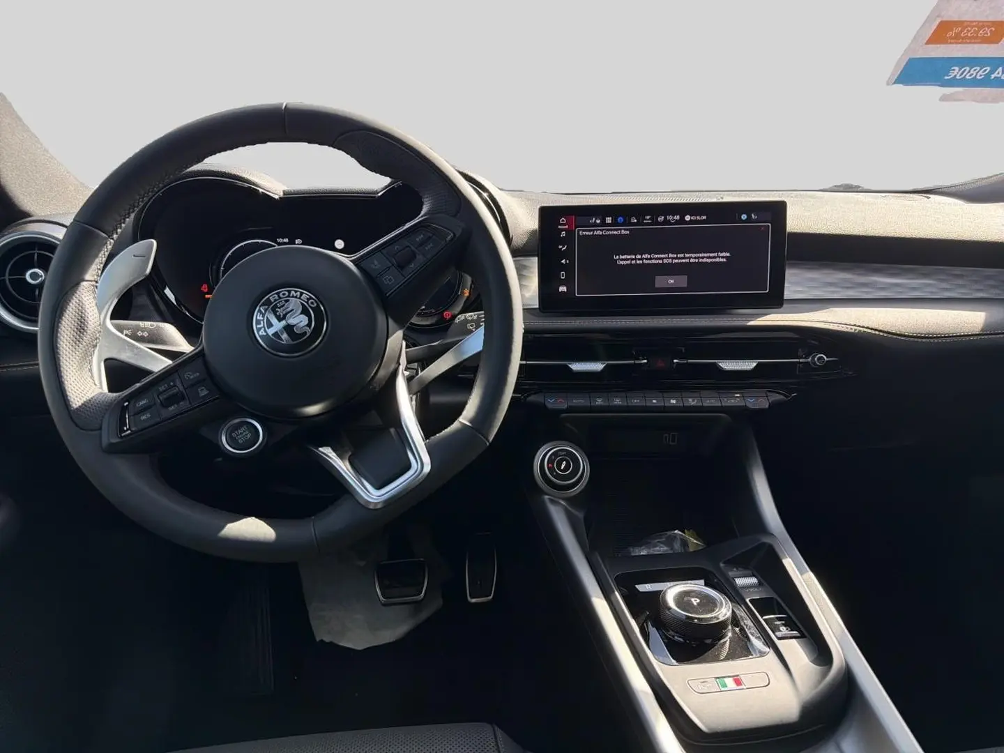 Vue intérieure de face du poste de conduite de l'Alfa Romeo Tonale 2025 avec volant cuir et écran tactile central.