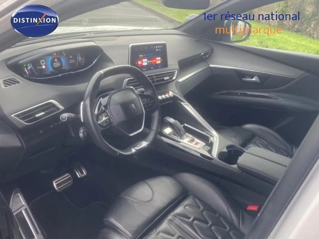 Vue intérieure côté conducteur du Peugeot 3008 blanc, mettant en valeur le volant cuir et l'écran tactile central.