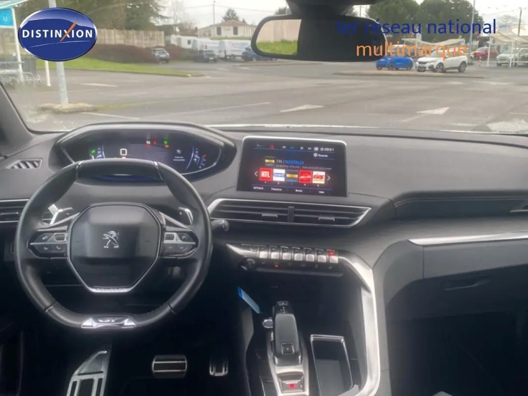 Vue intérieure du poste de conduite du Peugeot 3008 blanc de 2018, avec volant cuir et écran tactile central.