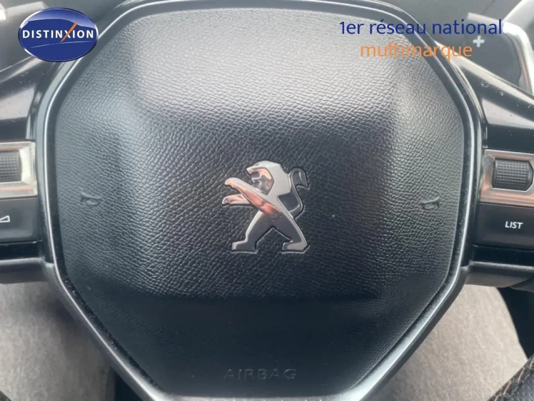 Gros plan sur le volant cuir noir avec logo Peugeot du SUV 3008 blanc, version GT de 2018.