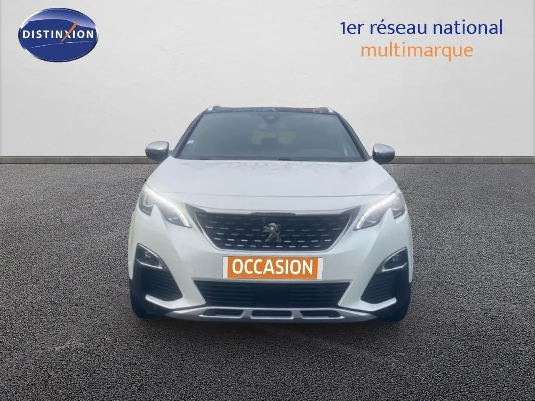 Vue avant d'un Peugeot 3008 blanc avec phares allumés et plaque "OCCASION" sur un sol gris.