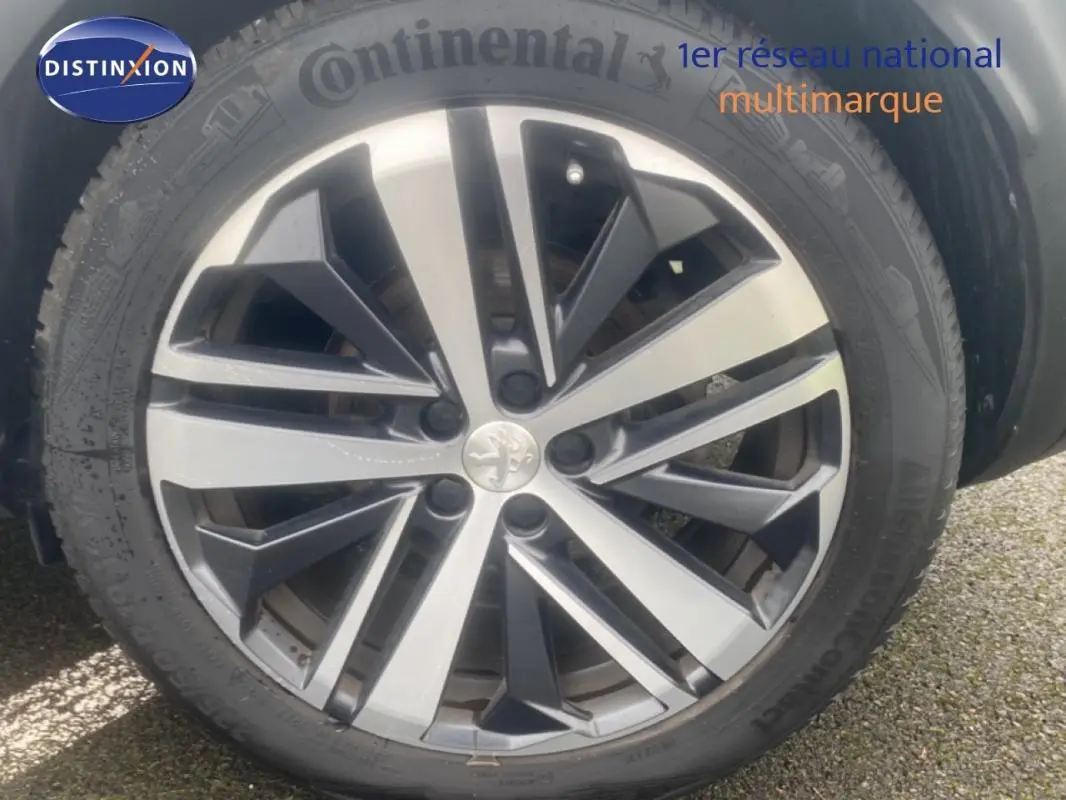 Gros plan sur la jante alliage 19 pouces du Peugeot 3008 blanc, mettant en valeur le logo lion au centre.