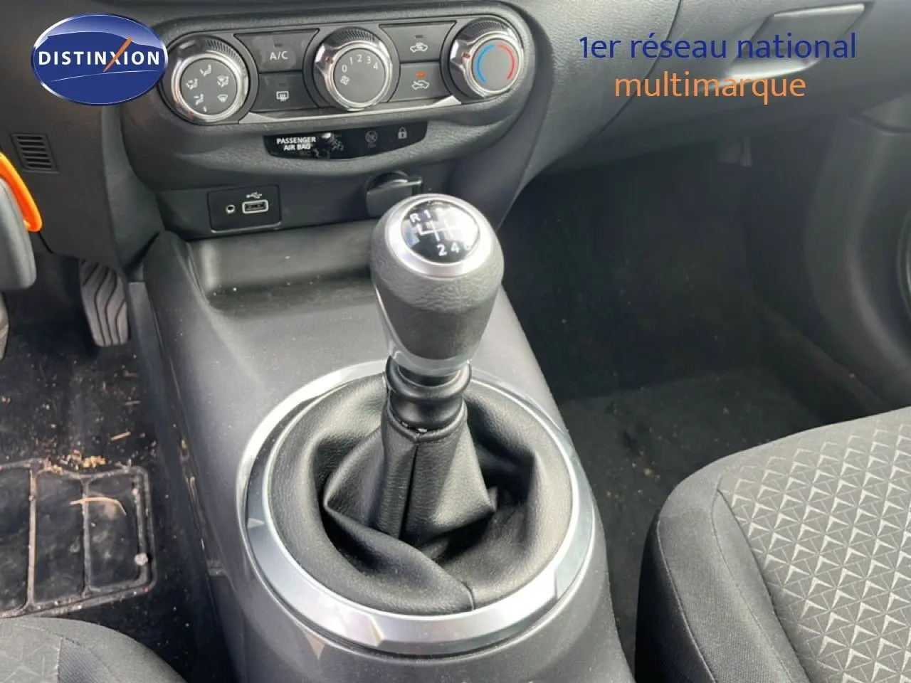 Gros plan sur la console centrale avec levier de vitesse manuel et commandes de climatisation d’un Nissan Juke noir.
