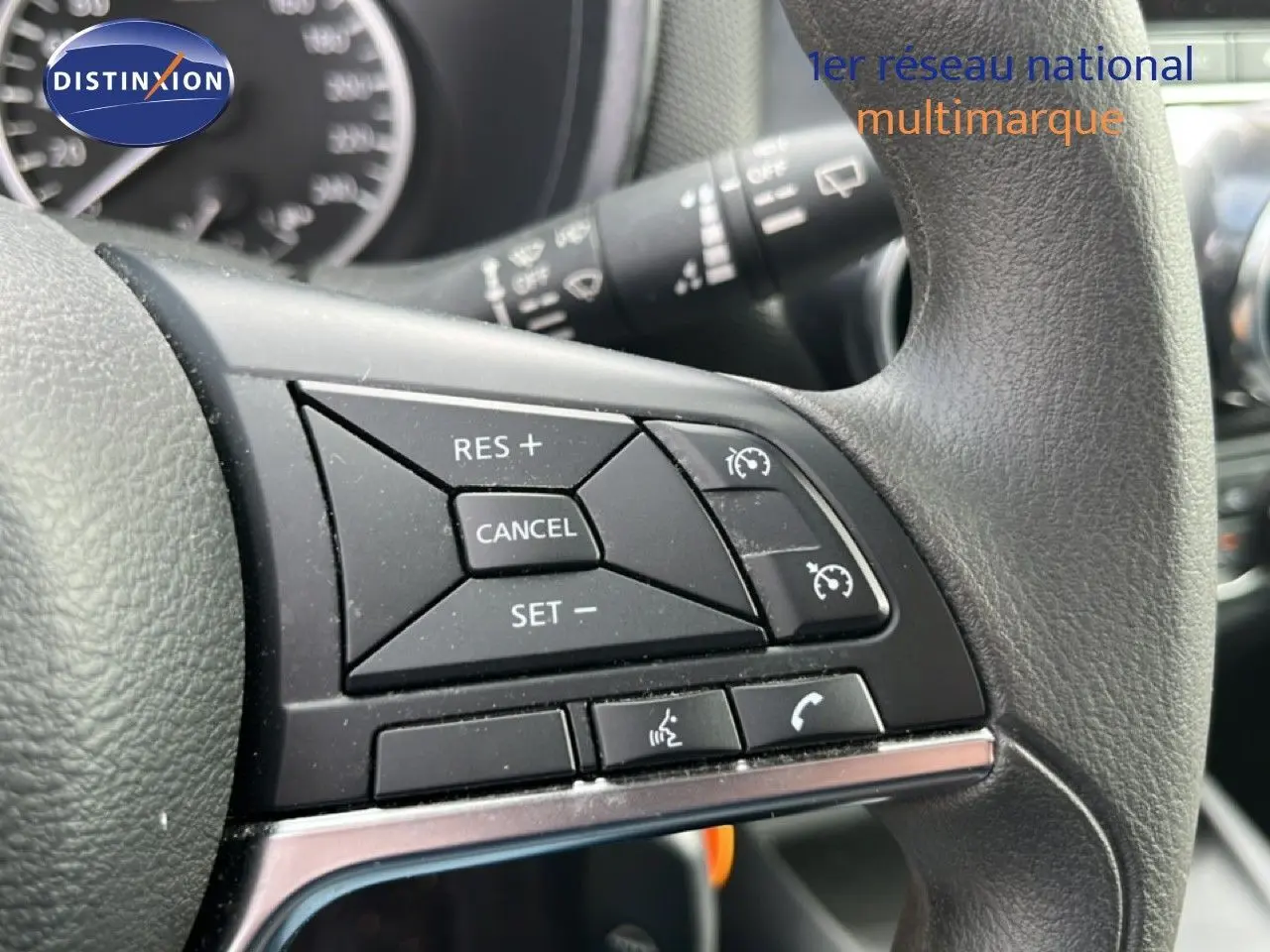 Gros plan sur les commandes au volant du Nissan Juke 2023 noir métal, mettant en valeur les boutons de régulateur de vitesse.